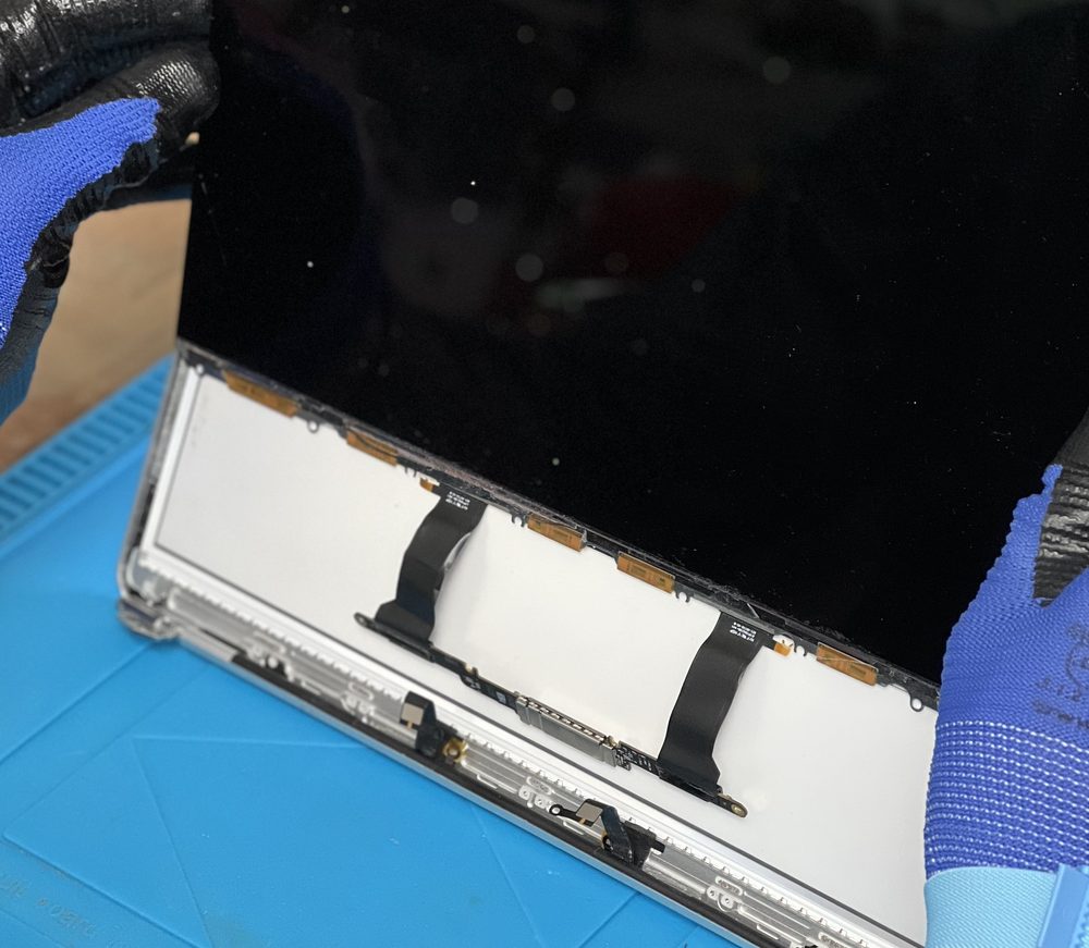 Ausgebautes MacBook-Display auf der Werkbank